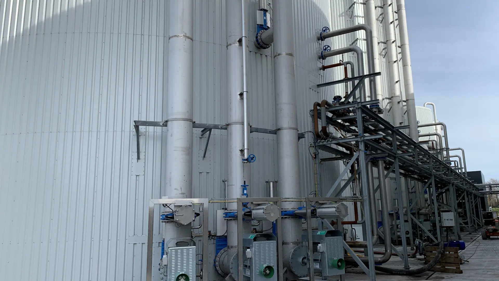 DN600 inox leidingen gemonteerd tegen een grote witte biomassatank
