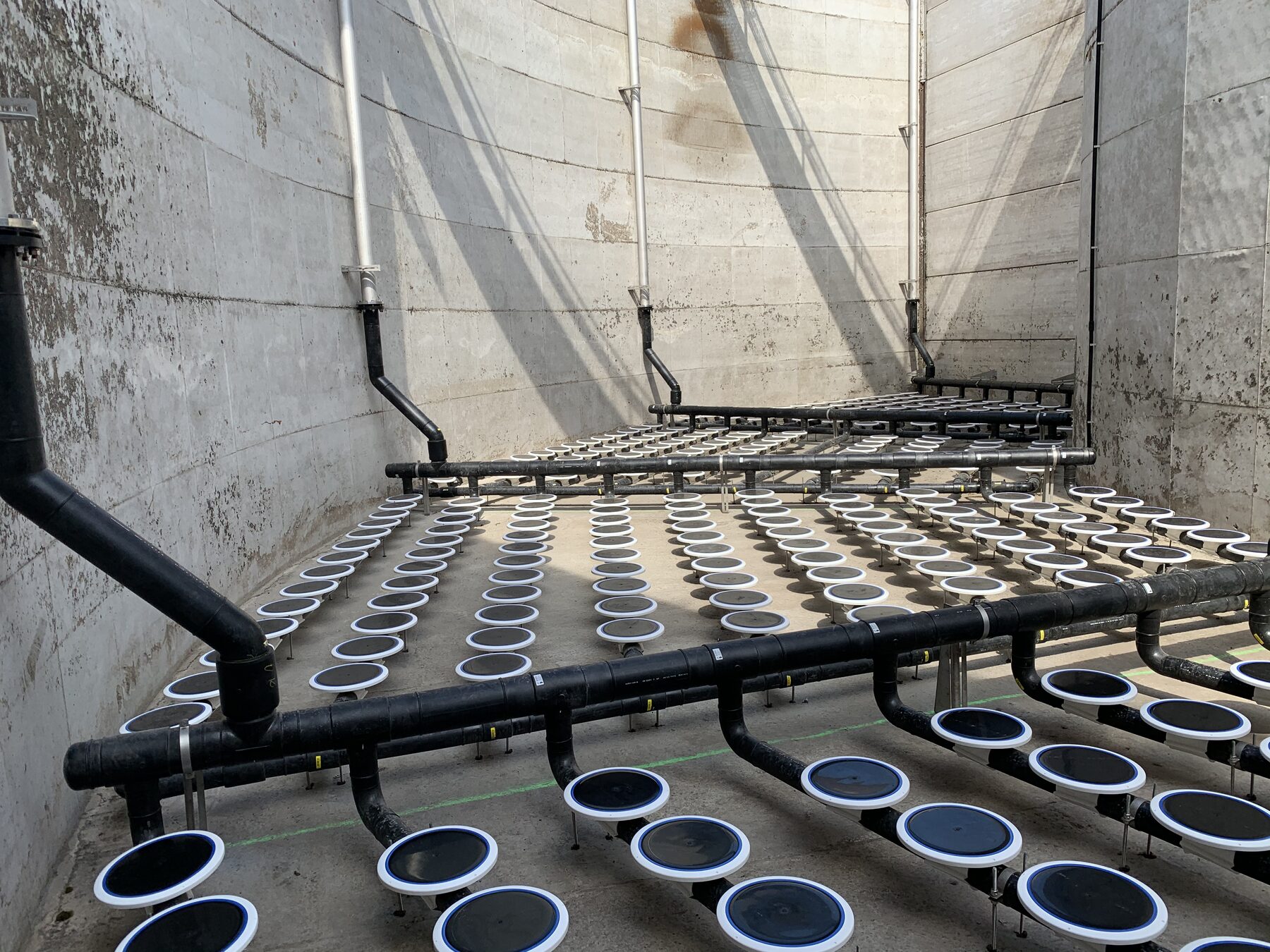 Beluchtingsgrid met fijnbellenbeluchters in een betonnen tank